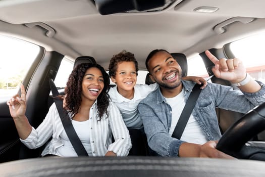 Road Trip. Happy Black Family Of Three Riding Car And Singing Songs Having Fun Traveling By Automobile. Cheerful Parents And Kid Son Enjoying Auto Ride Together On Weekend