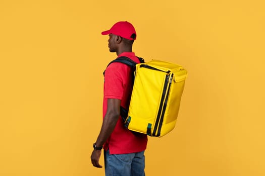 Millennial calm black deliveryman in red uniform with big backpack