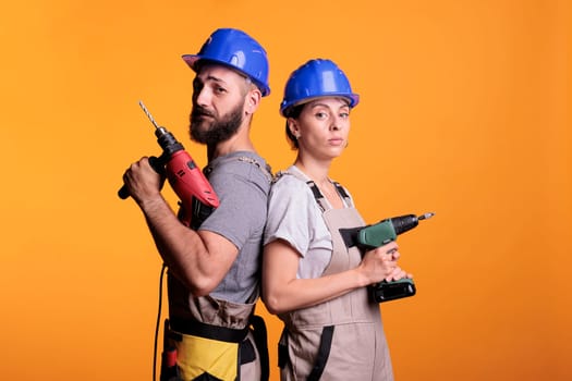 Construction workers posing with electric power drills