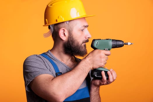 Male contractor holding electric drilling gun