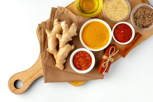 Ginger root and various spices on white background