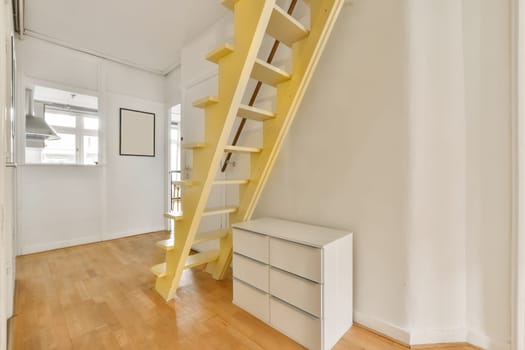 a yellow ladder in a white room with a staircase
