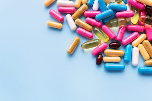 Medicine and healthcare concept. Macro shot of colorful bright tablets and capsules on a blue background. Place for an inscription.
