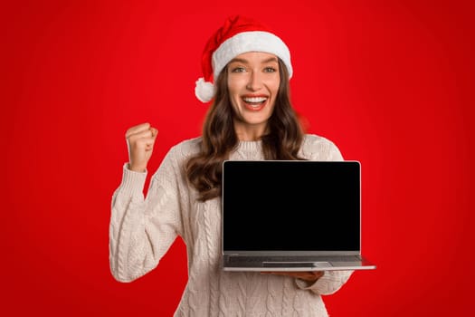 Excited lady with laptop gesturing YES showing screen, red background