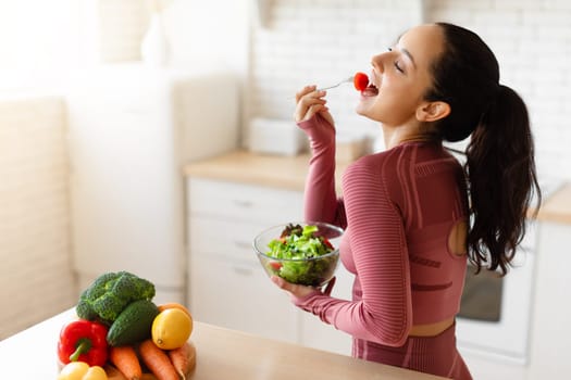 Fitness Lady Tasting Salad, Enjoying Healthy Dinner In Modern Kitchen