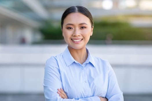 Portrait Of Confident Young Asian Businesswoman Standing In Urban Area