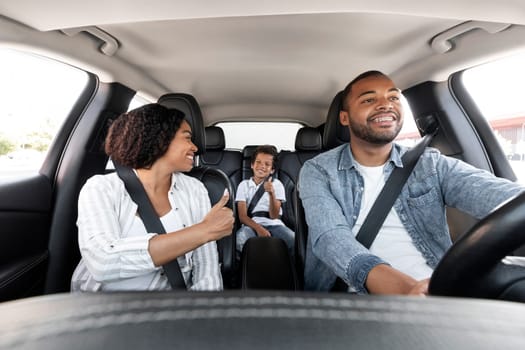 Happy black family enjoying car ride together