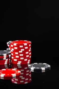 Red and black poker chips on black background