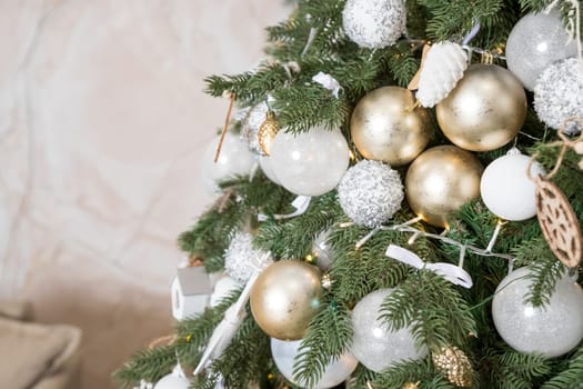 Christmas tree, New Year home decorations, golden ans silver balls, festive tree decorated with garland, baubles, traditional celebration. Copy space