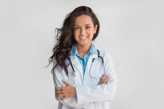 Confident female doctor with stethoscope, arms crossed