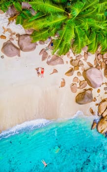 Drone view from above at Anse Lazio beach Praslin Island Seychelles, couple men and woman on beach