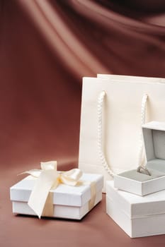 White jewelry boxes on brown silk background
