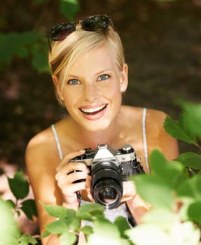 Happy, portrait and photographer with woman in forest for relax, memory and travel photography. Summer, trees and adventure with person and camera for vacation, holiday and environmental tourism