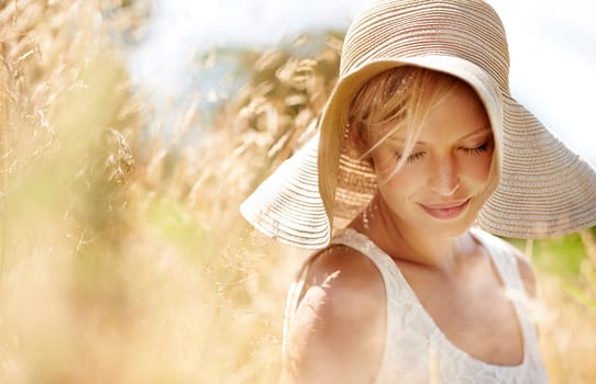 Summer, hat and wheat with woman in field for travel, vacation and holiday. Thinking, peace and nature with female person and grass in countryside meadow for calm environment, spring and sunshine.