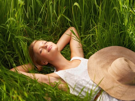 Nature field, grass and relax woman sleeping, tired or nap for outdoor sunshine, morning wellness or rest. Forest garden, woods or eco person dream, spring comfort or park break on natural green lawn