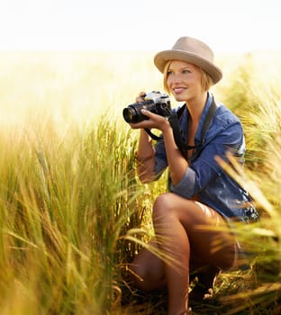 Sunshine, countryside and woman with a camera, photographer and freedom with tourism, travelling and nature. Person, photography or girl with vacation, thinking or journey with picture or creative