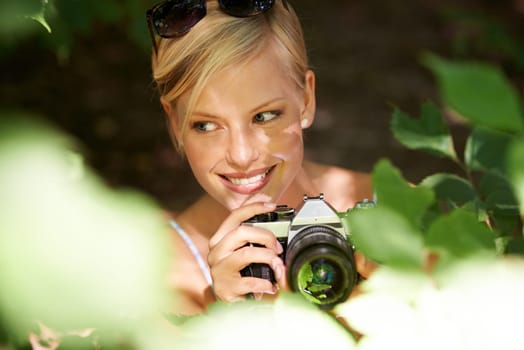 Smile, photographer and nature with woman in forest for trees, environment and relax. Shooting, camera lens and photography with face of female person in woods for travel, torusim and summer