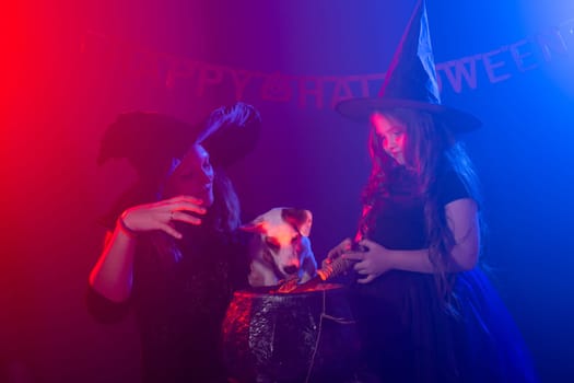 Two halloween witches making magic in halloween night. Magic, holidays and mystic concept.