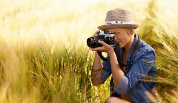 Woman, camera and photography in grass with travel, vacation and holiday with wheat field and plants. Nature, photographer and outdoor with blog and countryside with photo for adventure and journey
