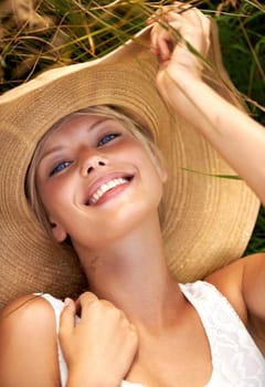 Summer, hat and portrait with woman in field for travel, vacation and holiday. Smile, peace and nature with female person and grass in countryside meadow for calm environment, spring and sunshine