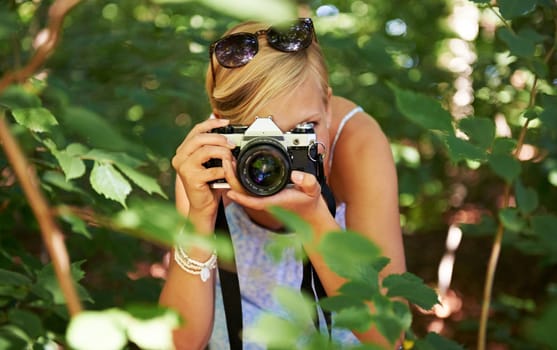 Camera lens, shooting and photographer with woman in forest for relax, memory and travel photography. Summer, trees and adventure with person in nature for vacation, holiday and environmental tourism