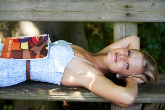 Portrait, relax and book with woman on park bench for literature, summer and happiness. Calm, nature and peace with young female person reading in countryside for knowledge, learning and studying