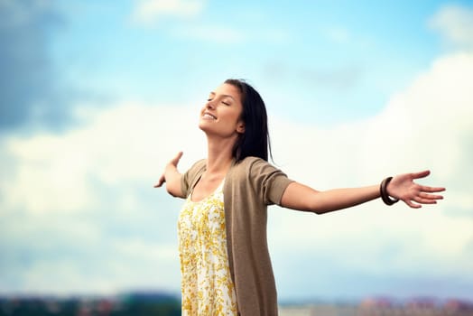 Woman, arms spread and happy on rooftop, adventure and freedom on trip to Norway, joy and sky background. Female person, vacation and relax or positive for getaway, energy and stretching in holiday