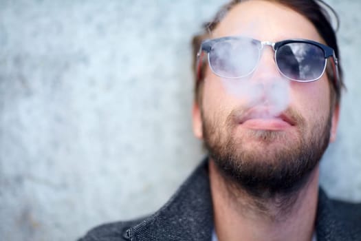 Face, man and smoking outdoor with sunglasses for addiction, experience and enjoyment on mock up space. Person, hipster and smoke on mockup for lifestyle, luxury and exhale or tobacco satisfaction