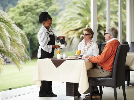 Waitress, coffee and senior couple on cafe patio on romantic date together at restaurant table. Old man, woman and server pouring drink at breakfast in luxury hospitality, hotel and relax on terrace.