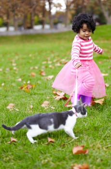Nature, walking and girl with kitten in a garden on the grass on a summer weekend together. Happy, sunshine and portrait of child playing and having fun with cat or feline animal pet on lawn in field
