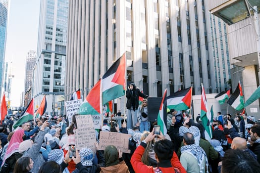Toronto, Canada - 28 October 2023: Anti-war march in Toronto by Palestinians against Israel's aggression in Gaza. City's peaceful protest against Israel-HAMAS war. Protesters wave flags