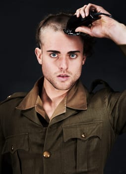 Military, soldier and portrait of man in haircut at studio isolated on a black background. Army, serious face and person shave hair with machine for grooming to prepare for service, bootcamp and war