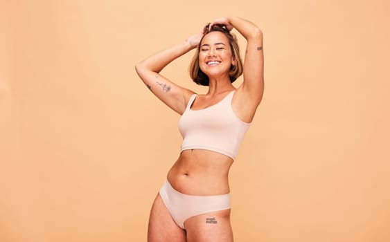 Happy, lingerie and body of woman in studio isolated on a brown background mockup space. Smile, underwear and model in natural beauty, self love and confidence for positivity, health and wellness