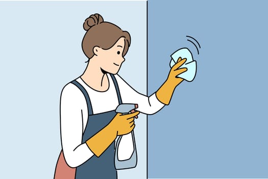 Housewife woman cleaning apartment, wiping wall or glass using antibacterial spray