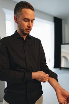 Portrait of a man in black shirt posing in photostudio