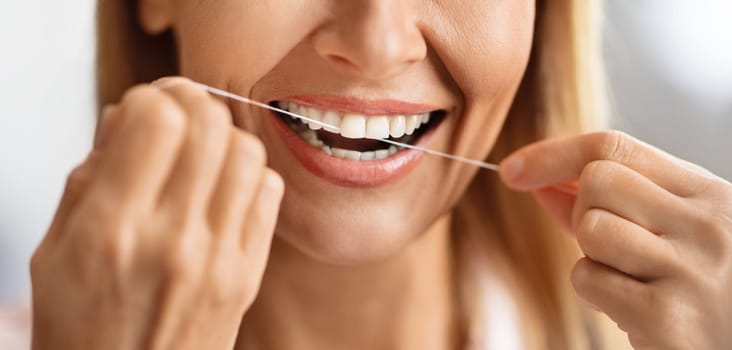 Oral Care. Closeup Shot Of Smiling Mature Female Using Dental Floss
