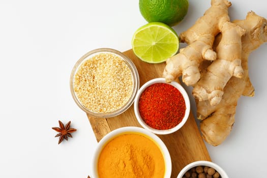 Ginger root and various spices on white background