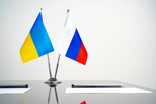Russia and Ukraine flags on negotiation table