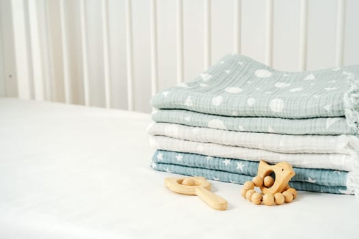 Stack of cotton blankets for a newborn in a cradle