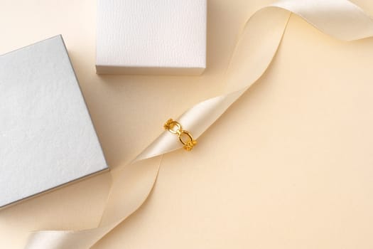 Golden jewelry ring on ribbon studio shot