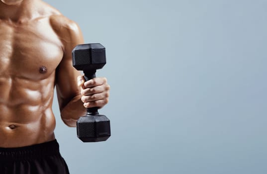 athlete guy holding dumbbell flexing arm muscles over gray background
