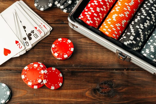 Playing cards and chips in a case on wooden table