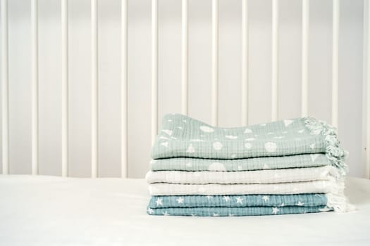 Stack of cotton blankets for a newborn in a cradle