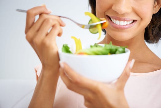 Smile, health and closeup of woman with salad in studio with vegetables for wellness, organic or diet. Happy, nutrition and zoom of female person eating healthy meal with produce by white background.