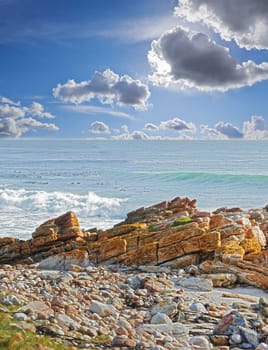 A rocky coastline in the Western Cape, South Africa on a hot summer day. Clear sky and beaches, a perfect getaway filled with self care resorts and wellness outdoor activities with tropical weather