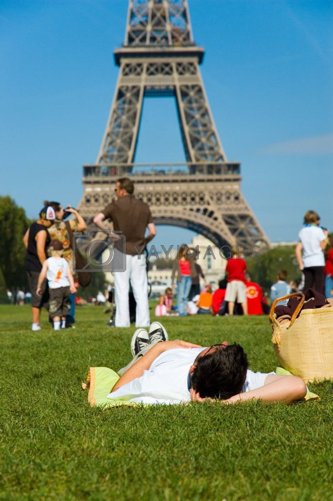 Royalty free image of Man laying on the ground and looking at Tour Eiffel by iribo