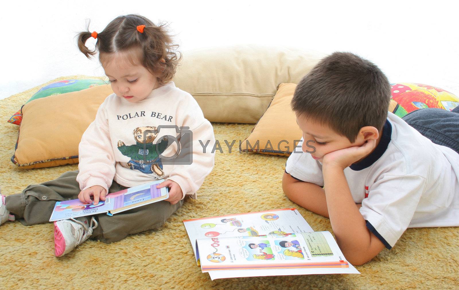 Royalty free image of Brother and sister reading books on the floor by Erdosain