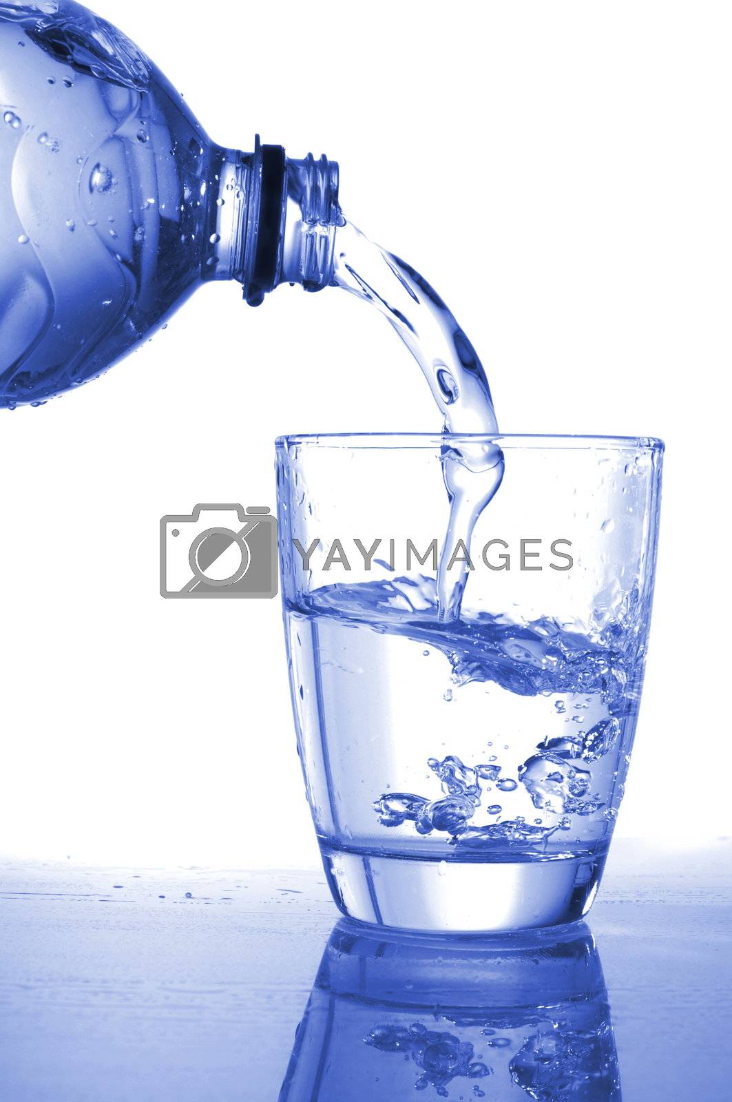 pouring fresh water in a glass on white                                    