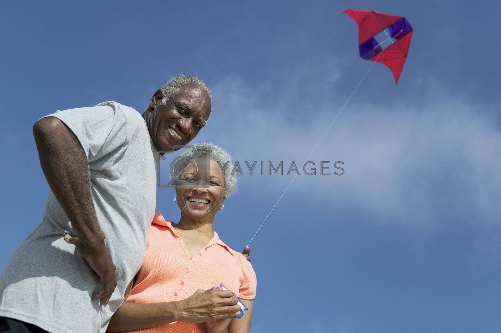 Royalty free image of Middle-Aged Couple Flying Kite by moodboard