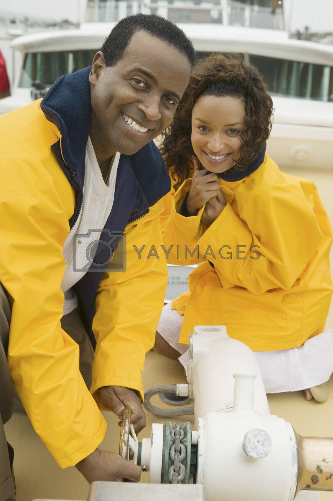 Royalty free image of Couple Dropping Anchor on Yacht by moodboard